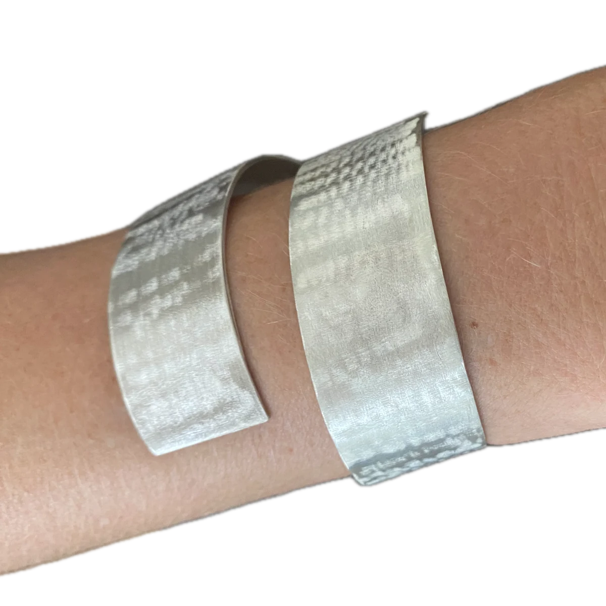 Zilveren armband met geborstelde structuur, gedragen om de pols